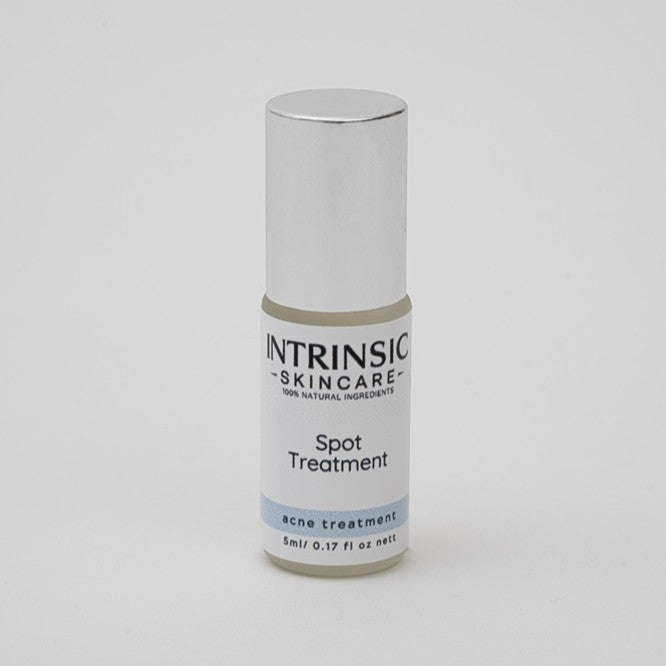 Intrinsic Skincare botanical spot treatment in a small glass bottle with a precision stainless steel rollerball.