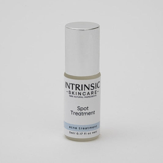 Intrinsic Skincare botanical spot treatment in a small glass bottle with a precision stainless steel rollerball.